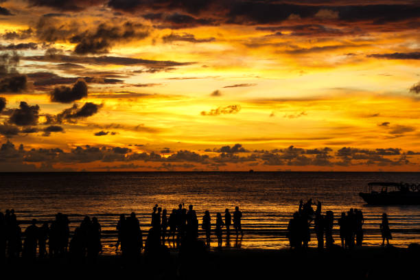 istock A silhouette of people at the beach during a beautiful sunset 2177708194