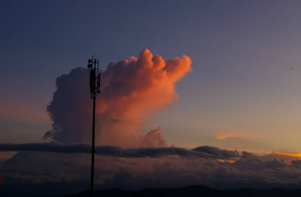 A silhouette of telco tower with beautiful sunset and cloud on the background
