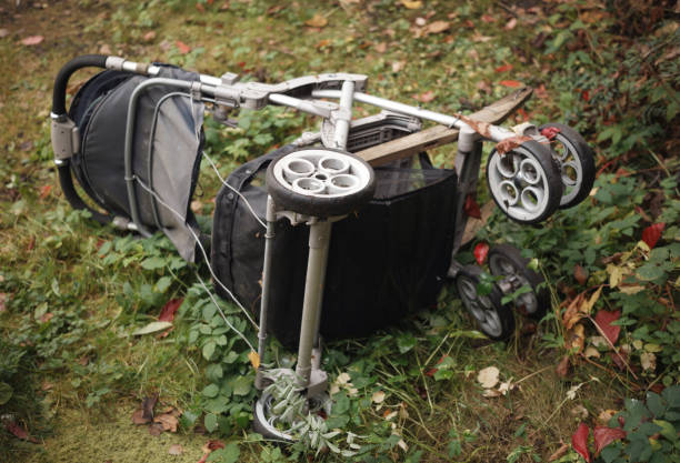 tipped over baby stroller abandoned on the ground, outdoor gloomy shot