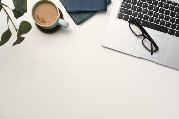 istock Top view white office desk with laptop, coffee cup and glasses and book 2177713179