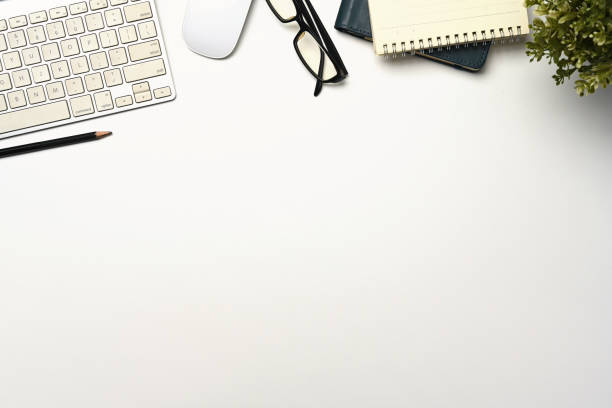 istock White office desk with computer keyboard, notepad and glasses. Top view 2177713192