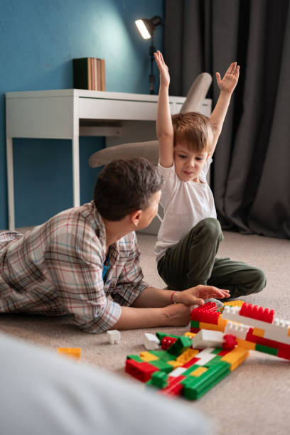 istock Mother and Child Interactive Play: Building and Learning with Colorful Blocks on the Floor, Enjoying Developmental Fun and Strengthening Their Bond in a Cozy Home Setting 2177713344