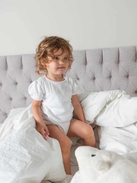 istock Toddler Playing in Bed with a White Stuffed Toy 2177713823