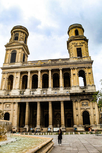 Image of a woman in front of the imponent Saint Sulpice in Paris