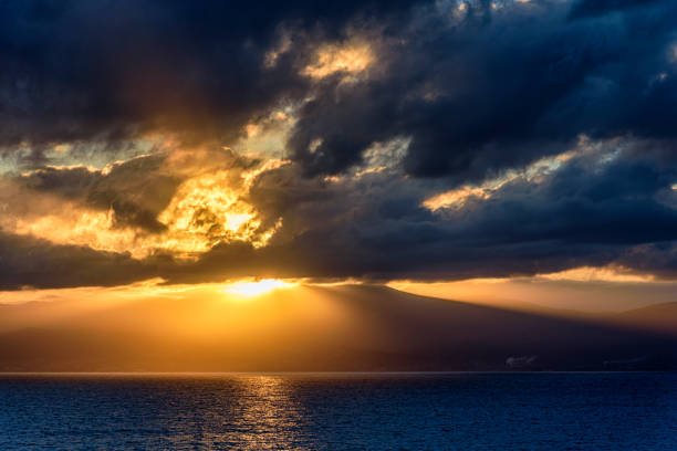 Witness the mesmerizing hues of the Hawaiian sky as the sun gracefully descends over the tranquil waters of Kaanapali Beach in Maui. This captivating image captures the essence of serenity, with warm oranges and soft purples blending seamlessly. The silhouetted palm trees and gentle waves add to the magic of this moment.