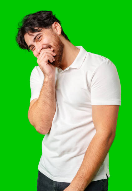 istock Young man with a beard smiles and poses in front of a bright green background 2177718072