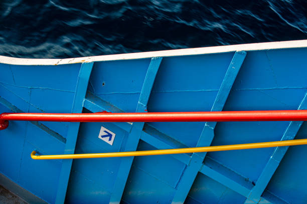 The ferry's blue painted hull and passenger handrails