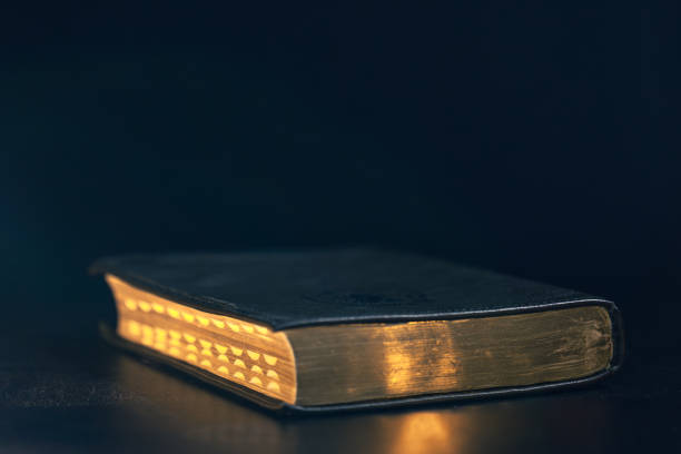 Bible on a black background. Religion concept. High quality photo. Bible with golden pages. Space for text.
