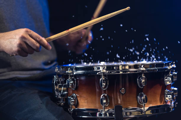 istock Drum sticks hitting snare drum with splashing water on black background. 2177720603