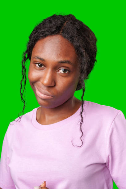 istock Young woman with curly hair shows a skeptical expression against a bright green background 2177720712
