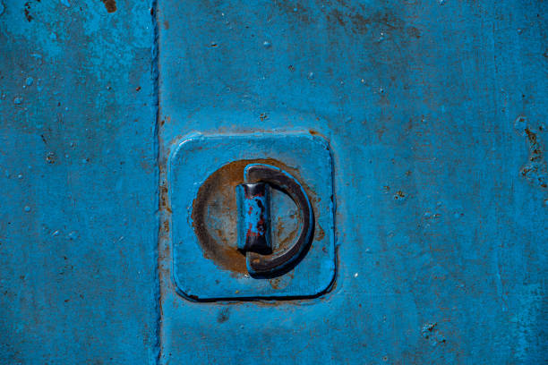 A blue painted floor of a ferry and a connecting hook