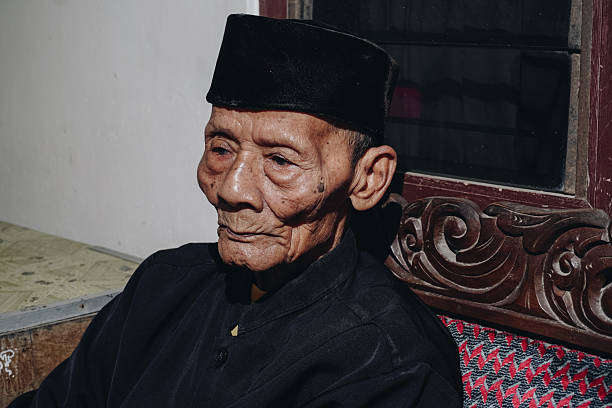 istock Thoughtful senior Asian man sitting on home sofa, looking away with thoughts. 2177722178
