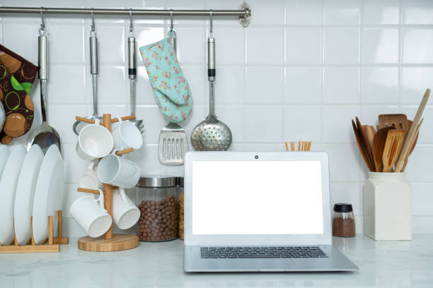 istock Mockup of laptop computer with empty screen sugar, spices in glass jars eggs, vegetable,tomato and a whisk on the kitchen on white table. Flat lay. Concept of food preparation, on background. 2177723481