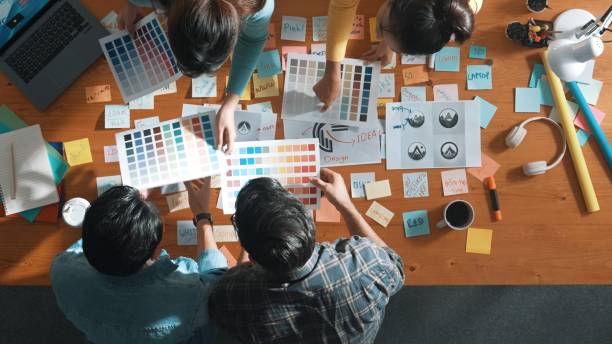 istock Top view of skilled designer holding logo while discussing with team. Symposium. 2177724000