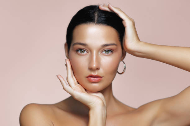 istock Latina Beauty with Glowing Skin Framing Face with Hands in Studio Portrait 2177724018