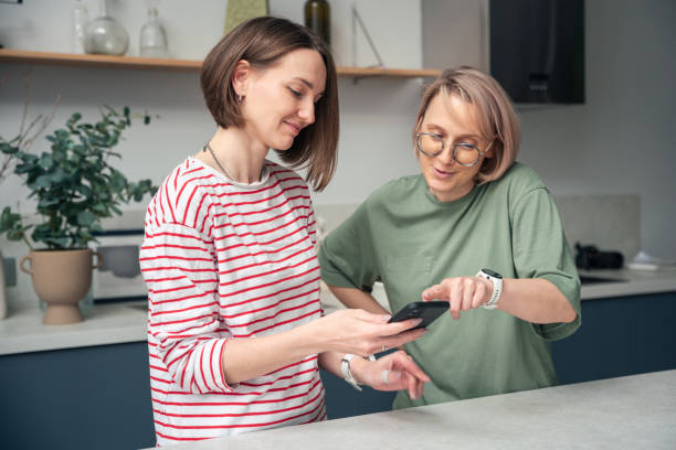 istock Two Women Sharing a Moment Using a Smartphone at Home 2177731020
