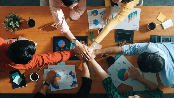 istock Top view of team put hands together at table with financial chart. Convocation 2177733635