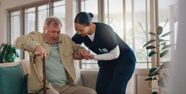 istock Senior man, nurse and help with walking stick, steps or holding hands for recovery on sofa in retirement home. Caregiver, woman and elderly person with disability, rehabilitation and cane for balance 2177737796