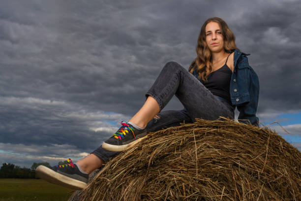 Boy sitting on bales of straw