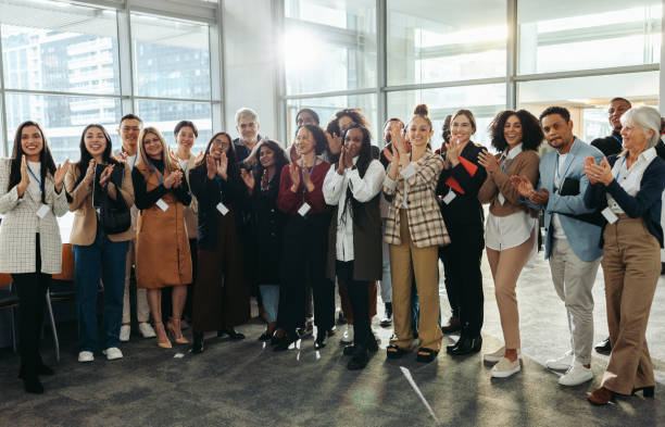 istock Diverse group of professionals applauding at a conference during corporate training session in a modern office setting 2177743398