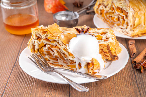 Sweet homemade pumpkin strudel. Tasty autumn pumpkin squash strudel cake with walnut and cinnamon, topped with vanilla ice cream scoop