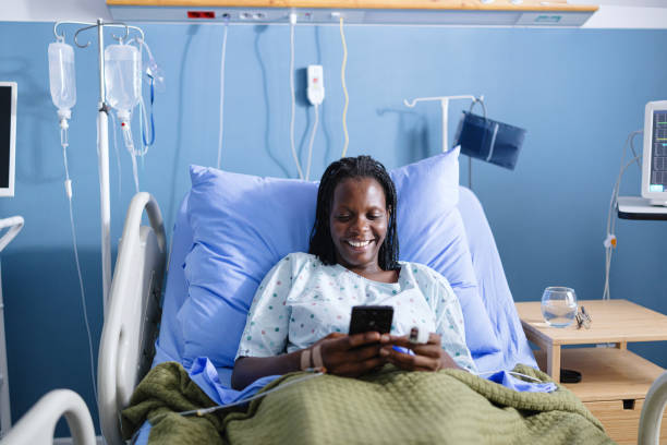istock Female patient texting with someone while lying in the hospital 2177759496