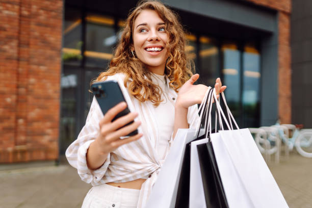 istock Woman with shopping bags and using cellphone. 2177759562