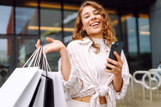 istock Woman with shopping bags and using cellphone. 2177759578