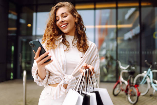 istock Woman with shopping bags and using cellphone. 2177759609