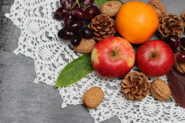 Autumn composition with fruit and leaves on grey background, top view. Healthy eating concept.