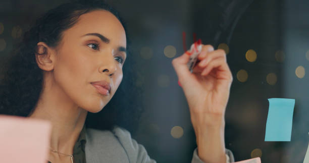 istock Business woman, writing and sticky note for planning, workflow or project management in office with agenda. African person, glass and brainstorming for schedule, research and timeline with objectives 2177766391