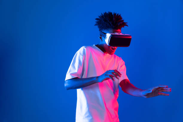 istock Young African player wearing VR point hologram 3D neon light wall. Contrivance. 2177768950
