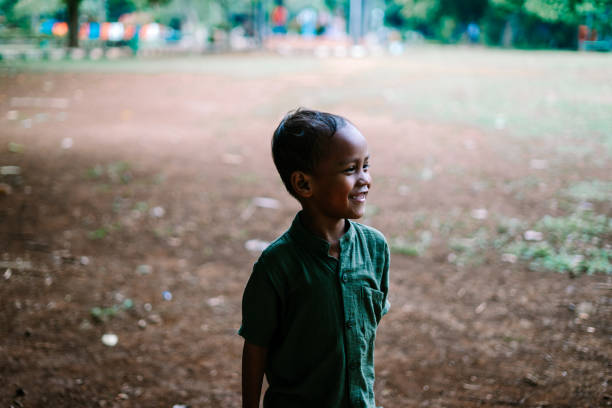 A young child standing in an open field, surrounded by greenery. Ideal for themes of childhood, nature, and outdoor exploration.