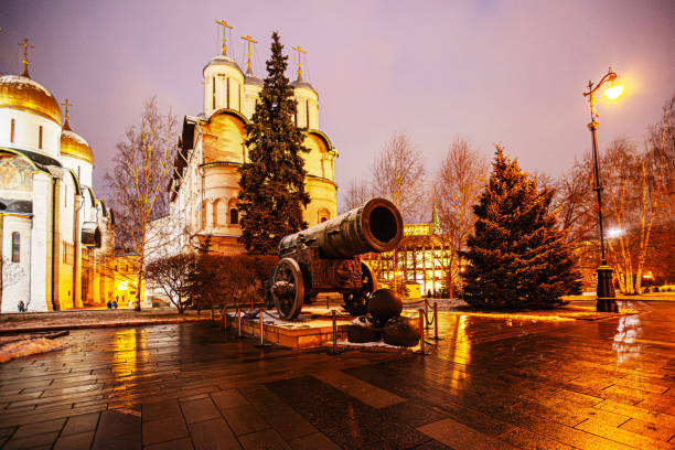 Moscow, Russia - November 25, 2018: The Tsar Cannon, located near the Ivan the Great Bell Tower in the Moscow Kremlin, is a massive artillery piece cast in 1586. Weighing 39 tons, it was designed for defense but has never been fired. The cannon features intricate engravings and symbolizes the power of the Russian state. The Ivan the Great Bell Tower, standing at 81 meters, is an architectural marvel completed in the early 16th century. Together, they represent Russia's military and cultural heritage, drawing visitors to explore their historical significance and craftsmanship.