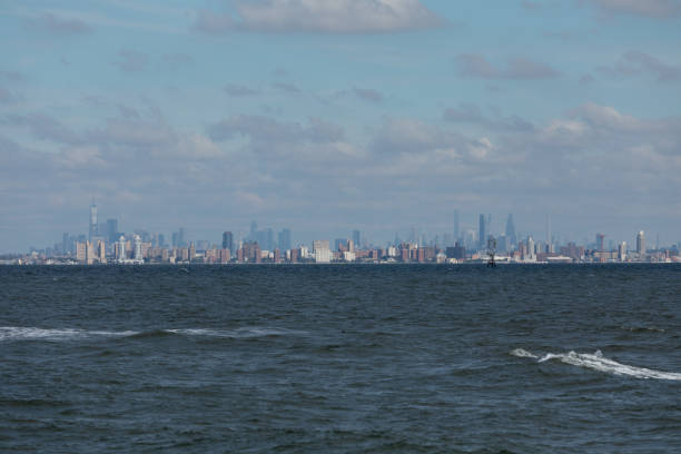 New York City is seen across the water from Sandy Hook, New Jersey. Brooklyn, including the famous Coney Island, can be seen in the front, with Manhattan Island behind.