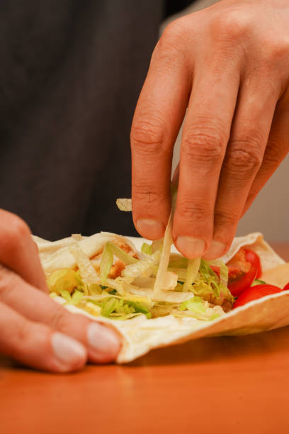 istock Opened chicken roll. Tortilla wrap with fried chicken meat and vegetables, close up. Shawarma tomato, cucumber, onion, lettuce and chicken meat. Fast food. Junk food. Eating. Food. Delicious. 2177782373