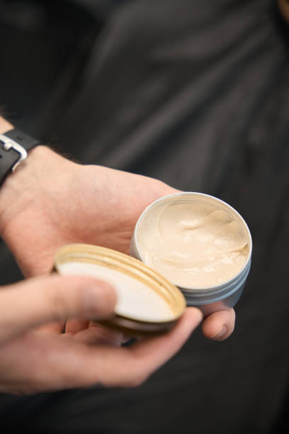 Expert stylist presents open container filled with creamy product