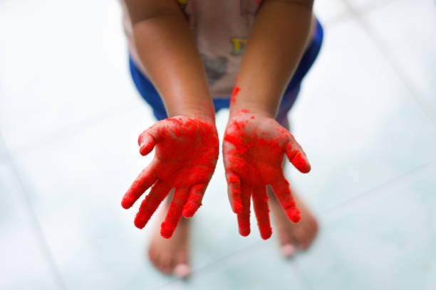 Little child's palms are red when playing with synthetic sand