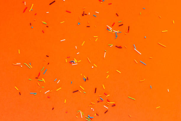 istock Sweet colorful sprinkles scattered on orange background 2177789279