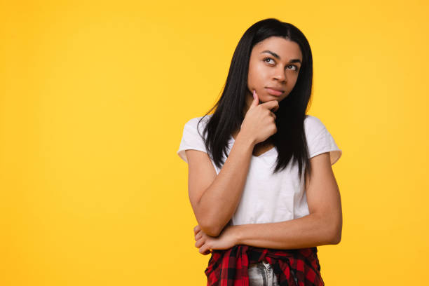 istock Black woman, studio and thinking of ideas for problem solving or planning, insight and brainstorming for decision. Girl, thoughtful and isolated on yellow background with mockup, pensive and choice. 2177790159
