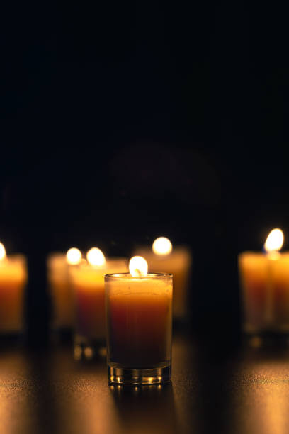 istock Burning candle on black background with backlight. Memorial Day. 2177791805