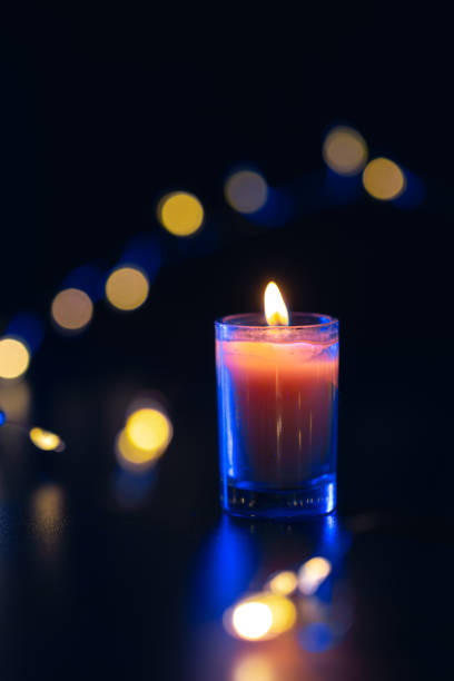 istock Burning candle on black background with bokeh. Memorial Day. 2177791815