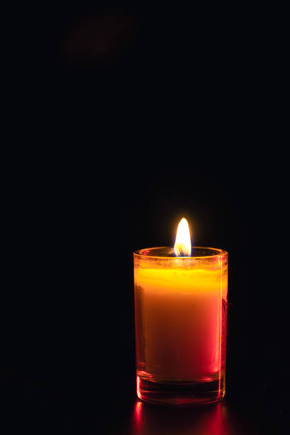 Burning candle on black background with backlight. . Memorial Day. High quality photo