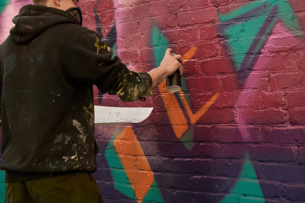 istock Guy with sketch spraying paint on wall 2177792624