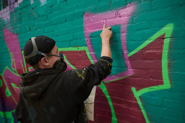 istock Spraying pink paint from can on wall 2177792655
