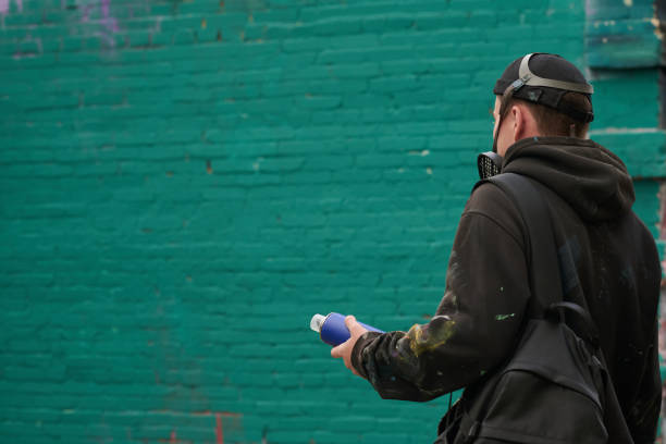 Grey paint used to cover up graffiti on an old yellow wall