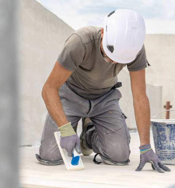 istock Craftsman in grey work clothes puts grout with a float sitting on his knees during construction 2177795369