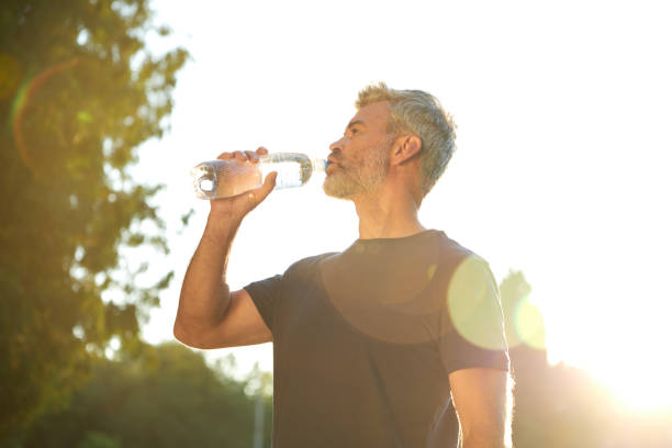 istock A Man Holding a Water Bottle in a Sunny Park While Undertaking an Outdoor Workout Session 2177801649