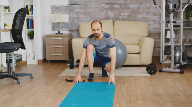 istock Man unrolled yoga mat 2177801720