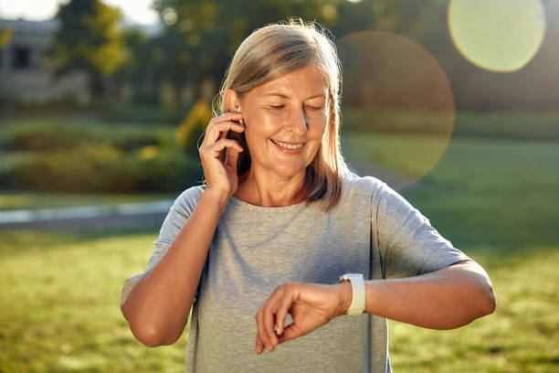 istock A Woman is Checking Her Smartwatch While Relaxing in a Sunlit Park on a Beautiful Day 2177801812